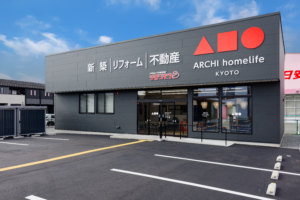 アーキホームライフ京都店の外観。新築・リフォーム・不動産を扱う店舗の正面と駐車場が見える。